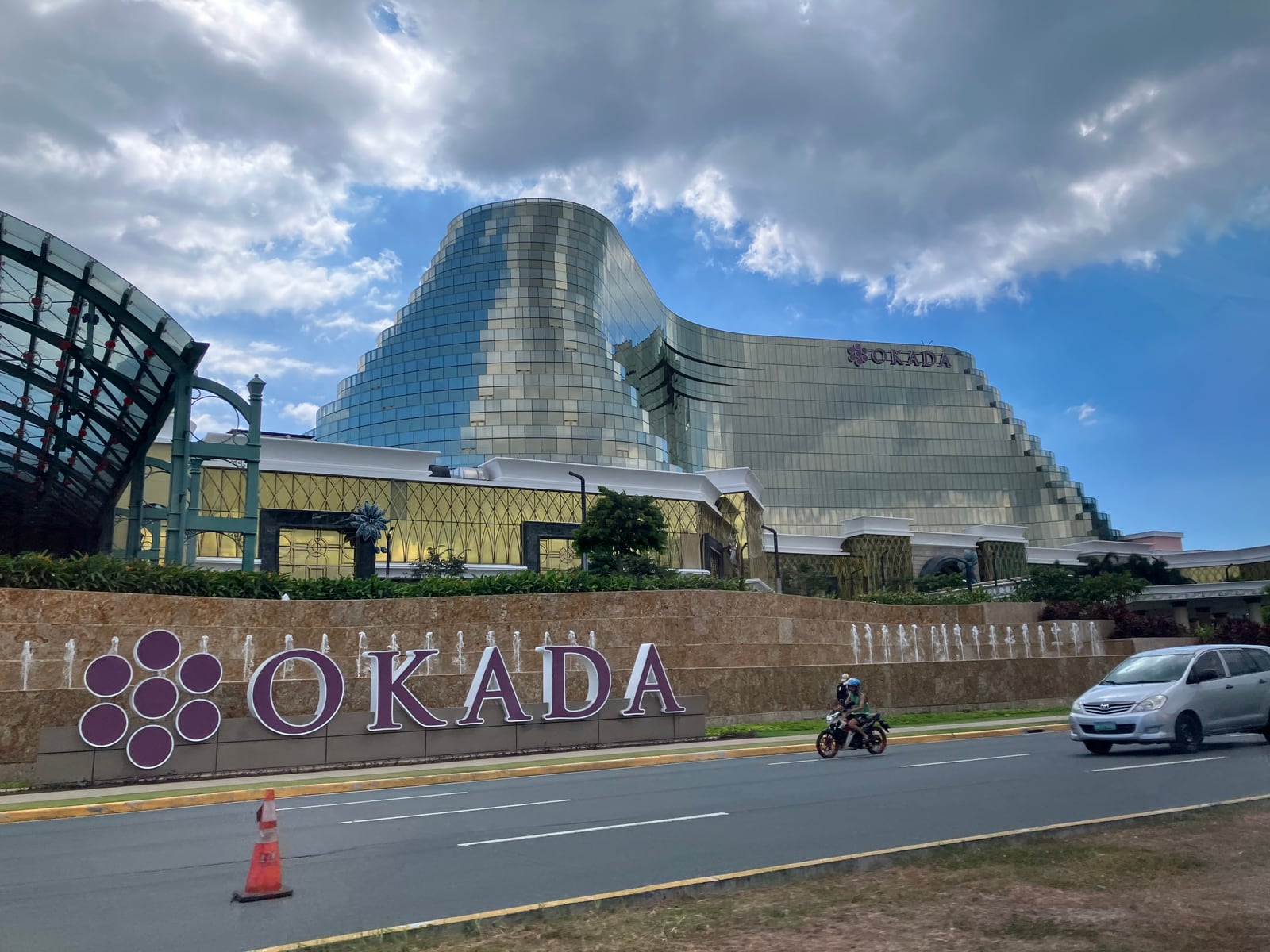 Okada Manila 金色弧形建築與臨路 OKADA 招牌,攝於 2024 年